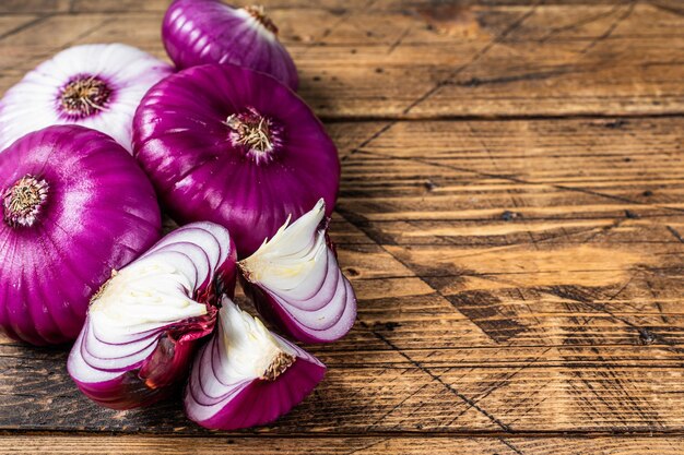 Photo sweet red onion on a wooden table. wooden background. top view. copy space.