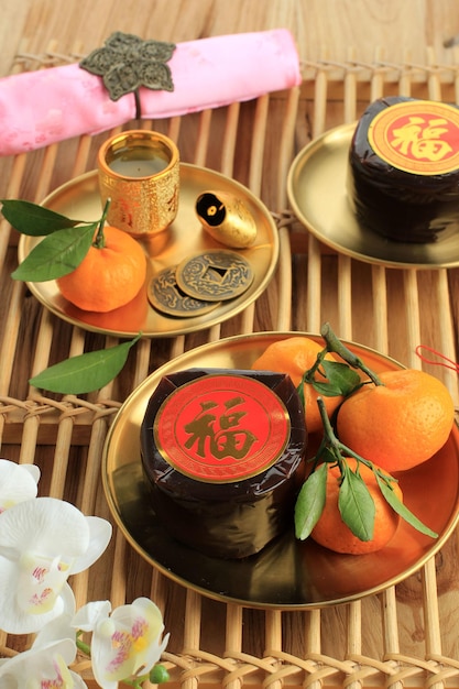 중국 신년 축제 또는 Sart Chin Day를 위한 달콤한 떡 Nian Gao(Kue Bakul 또는 Kue Keranjang). 한자 푸는 행운을 의미합니다. 차와 오렌지를 곁들인 Flatlay. 컨셉 차이니즈 페스티벌