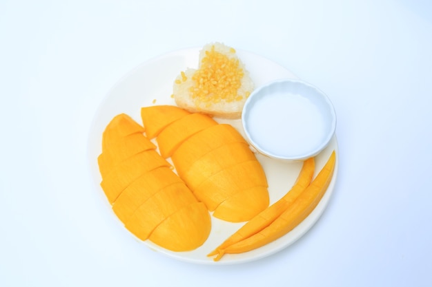 Sweet ripe golden mango and sticky with coconut cream on white circle ceramic plate isolated on white background