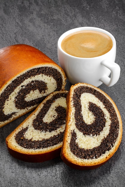 Sweet roll filled with poppy seed and cup of coffee