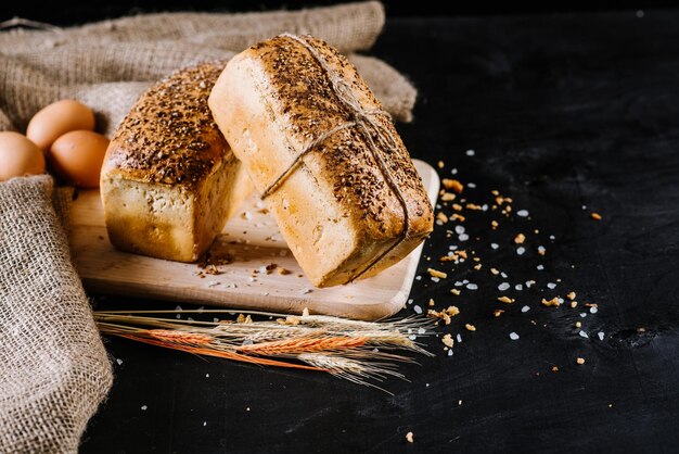 Sweet rye bread with different ingredients on black wooden background