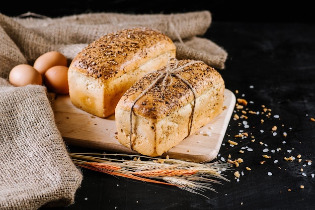 Pane di segale dolce con ingredienti diversi su fondo di legno nero