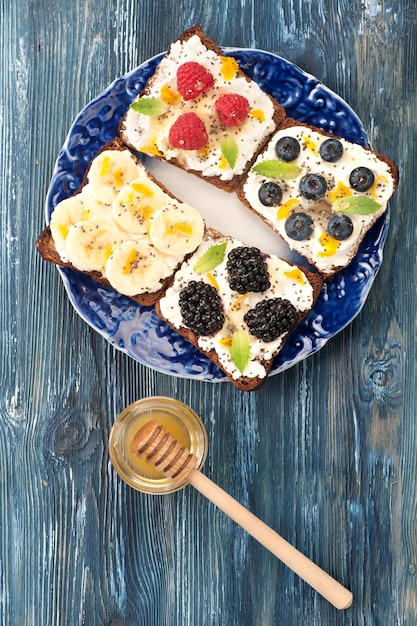 Sweet sandwich with berries fruit cream cheese chia seeds and honey A healthy breakfast Top view