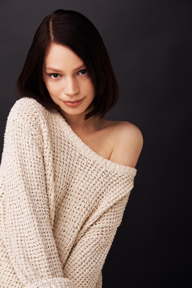 Photo 暗い背景に対して甘くて恥ずかしがり屋の魅力的な若い女性
