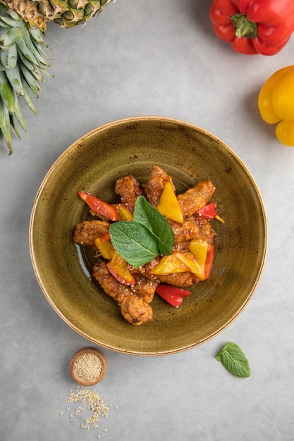 Sweet and sour chicken food and grey background bowl with sweet\
and sour chicken