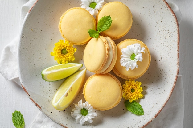 Sweet and sour lemon macaroons with spring flowers on plate