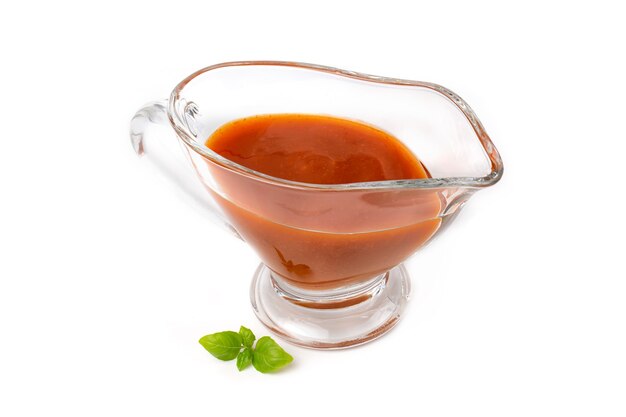 Sweet or spicy tomato chili sauce in a glass saucepan, isolated on a white background.