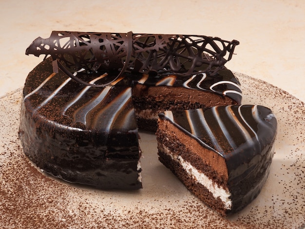 Photo sweet sponge chocolate cake on a plate decorated with cocoa powder