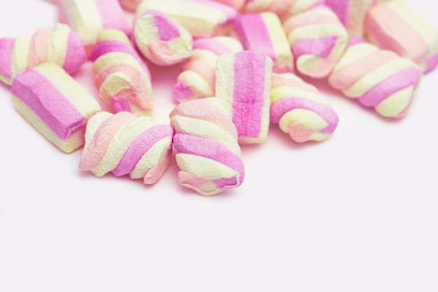 Foto caramelle gommosa e molle a strisce rosa e gialle dolci su bianco