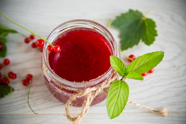 Dolce marmellata estiva di ribes rosso maturo in un barattolo