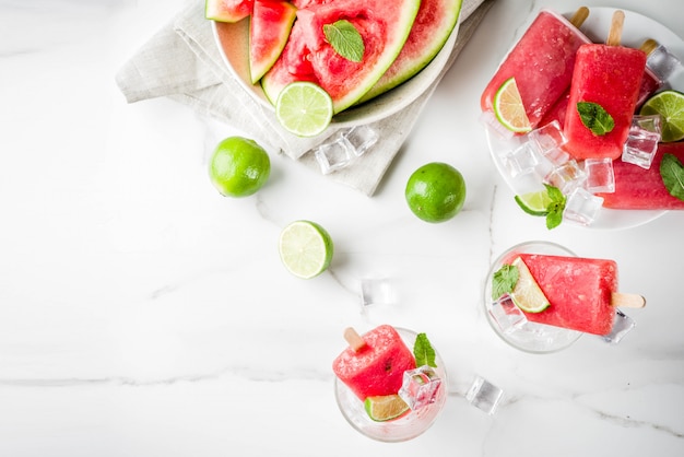 Sweet summer watermelon and lime popsicles with sliced watermelon and mint