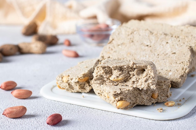 Foto halva di girasole dolce con arachidi su tavola bianca su sfondo grigio chiaro