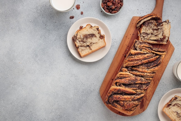 Photo sweet swirl homemade bread with poppy seeds on a grey concrete background