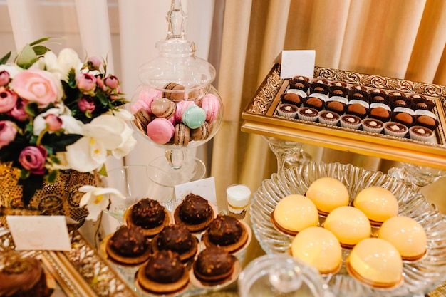 Sweet table A plates of cakes and muffins with cream with berries Table with sweets candy buffet Dessert table for a party goodies for the wedding Close up candy bar Decorated delicious