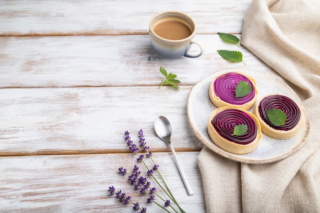 Sweet tartlets with jelly and milk cream with cup of coffee