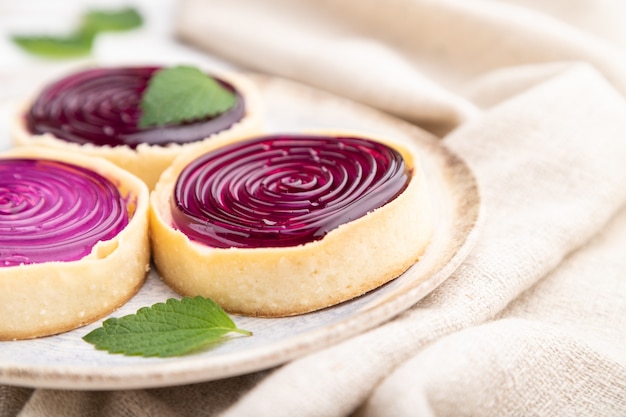 Sweet tartlets with jelly and milk cream with cup of coffee