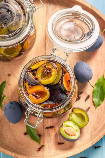 Sweet and tasty pickled plums in vinegar with cloves