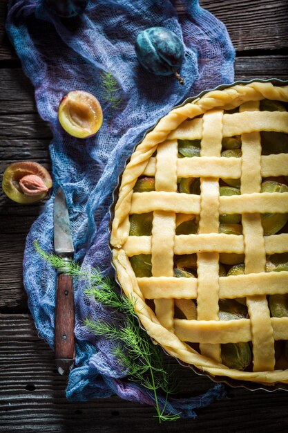 Sweet and tasty plum pie on blue cloth