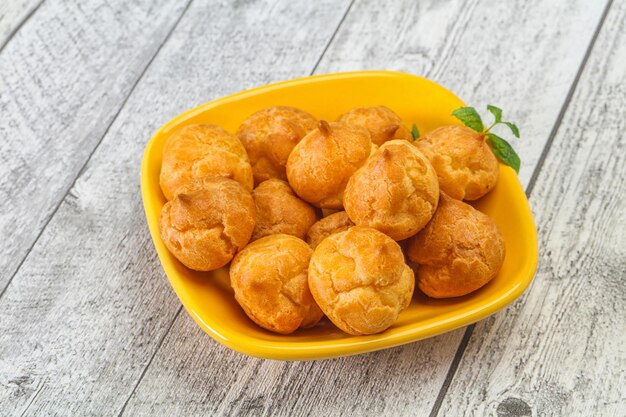 Sweet tasty profiteroles heap in the bowl