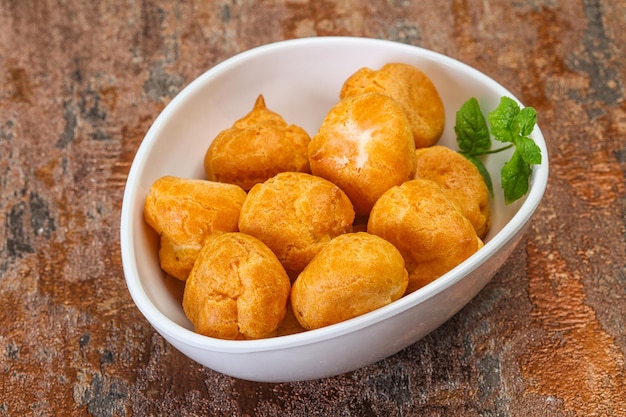 Sweet tasty profiteroles heap in the bowl