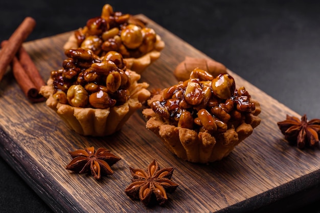 Sweet tasty tart with nuts and honey on a dark concrete background