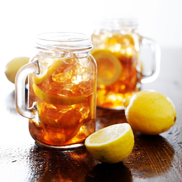 Photo sweet tea with lemon and ice in jars