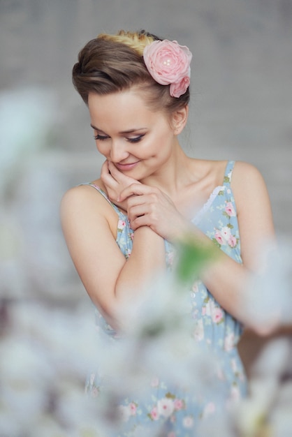 Sweet tender young woman girl pajamas flowers and plait hair dreaming posing in a studio