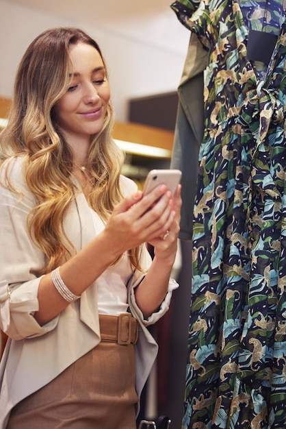 Photo sweet texts always make me smile shot of a young woman using her smartphone while shopping