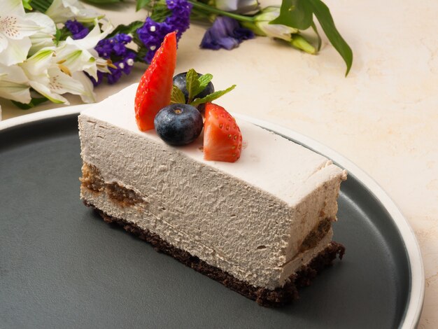 Sweet tiramisu is a classic Italian dessert on a dark plate