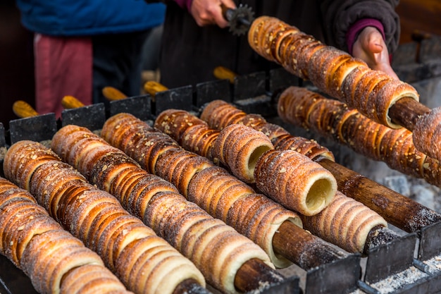 달콤한 간식 trdelnik, 나무 꼬치와 뜨거운 석탄에 준비된 전통적인 체코 디저트. 관광객들에게 인기있는 맛있는 베이커리