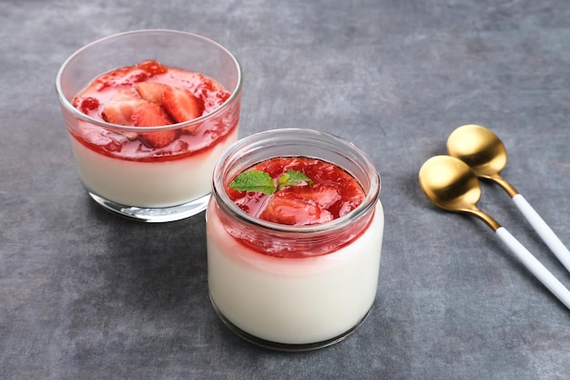 Sweet vanilla silky pudding dessert with strawberry sauce sliced fresh strawberries and mint leaf