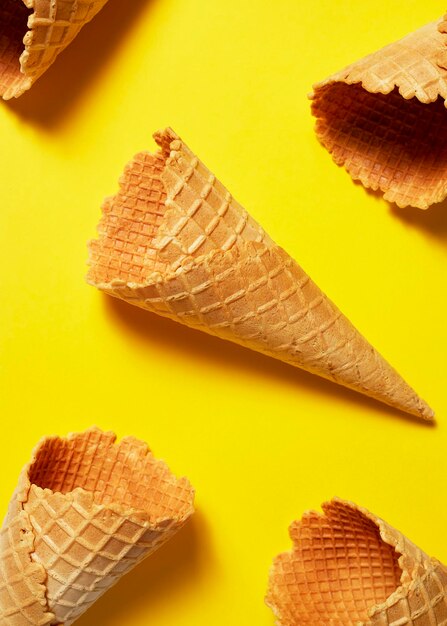 Sweet wafer ice cream cone on yellow background summer and empty concept top view flat lay