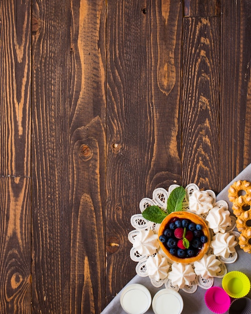 Sweet white meringue and other components on a wooden background, .