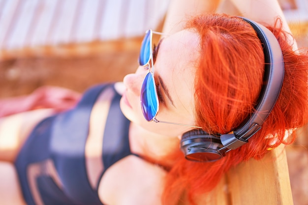 Sweet woman listening to music on the beach