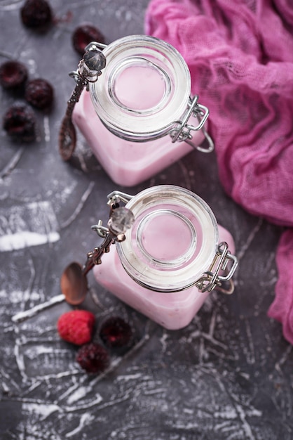 Sweet yogurt with berry in a glass jars