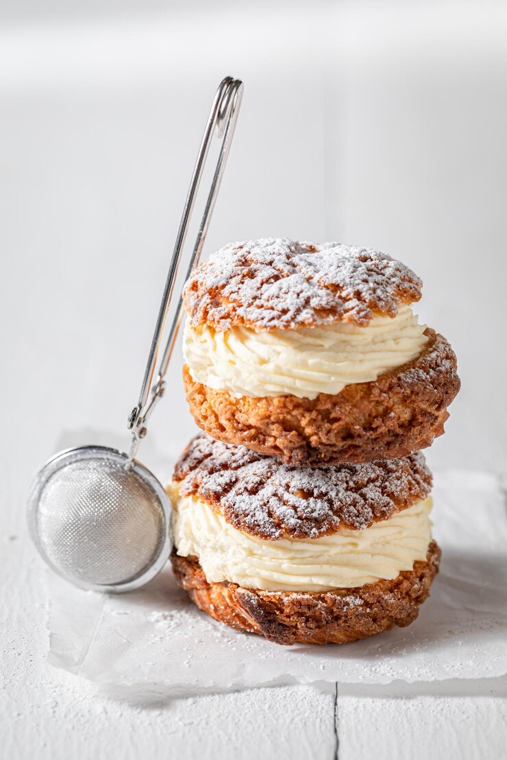 Photo sweet and yummy cream puffs with powdered sugar in strainer