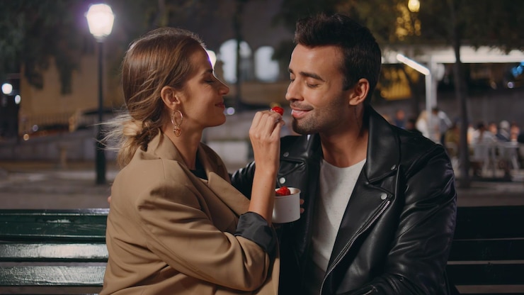 Photo sweethearts dating valentine evening eating strawberry on city street closeup