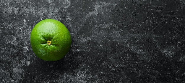 Sweetie groene citrusvruchten Op een zwarte stenen achtergrond Bovenaanzicht Gratis kopieerruimte