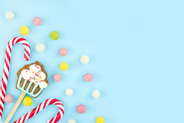 青い背景のスイーツキャンディークッキーとロリポップスウィートクリスマス杖上面図コピースペース