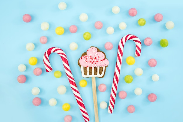 파란색 배경에 과자 사탕 쿠키와 막대 사탕 달콤한 크리스마스 지팡이 상위 뷰 복사 공간