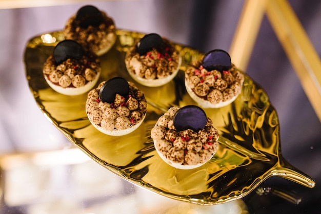 誕生日の洗礼式の結婚式を祝うためのデザート付きお菓子キャンディーバー 黄金の皿の上のデザート トップ ビュー