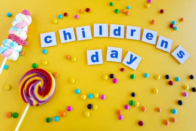 Sweets and chocolates on a yellow background happy children's day