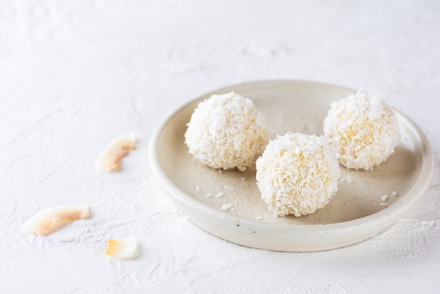 Sweets in coconut flakes on a plate sugar gluten and lactose free vegan