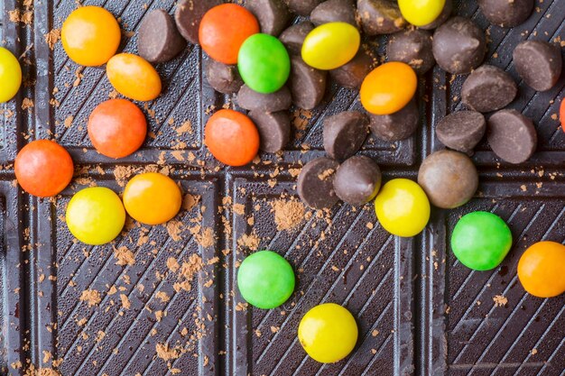 Sweety colorful candies over a chocolate bar