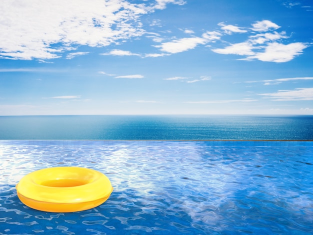 Swim ring on infinity pool with blue sea and blue sky