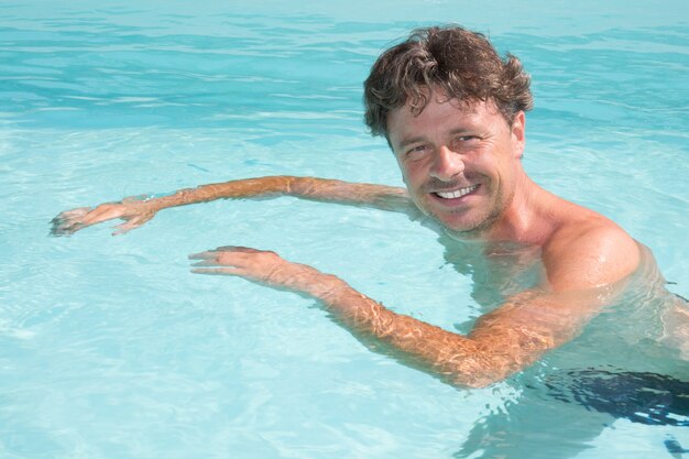 Swimmer man swims in swimming pool