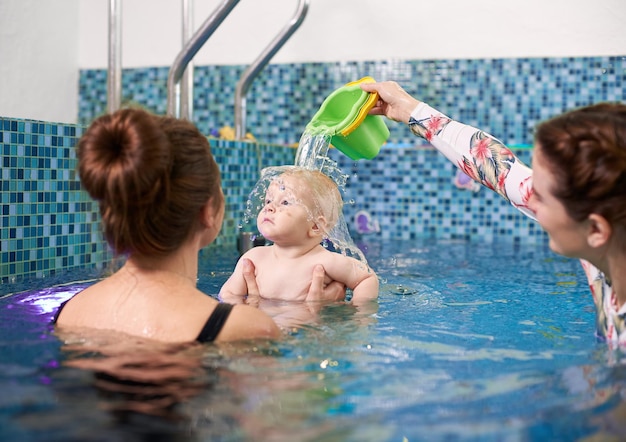 Swimming classes for little ones infant with mother in swimming pool during training