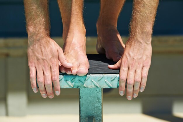 Foto gambe di nuoto e persona sportiva sul podio per l'esercizio fisico pratica all'aperto o gara di pratica mani impegno dell'atleta e nuotatore inizio competizione prestazioni cardio o allenamento per la competizione