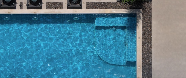 Плавательный бассейн с голубой водой летом, угол обзора сверху. Вид с воздуха на бассейн в солнечный день, который подходит для занятий спортом, отдыха в отпуске или тренировки, чтобы сжечь калории в отпуске.