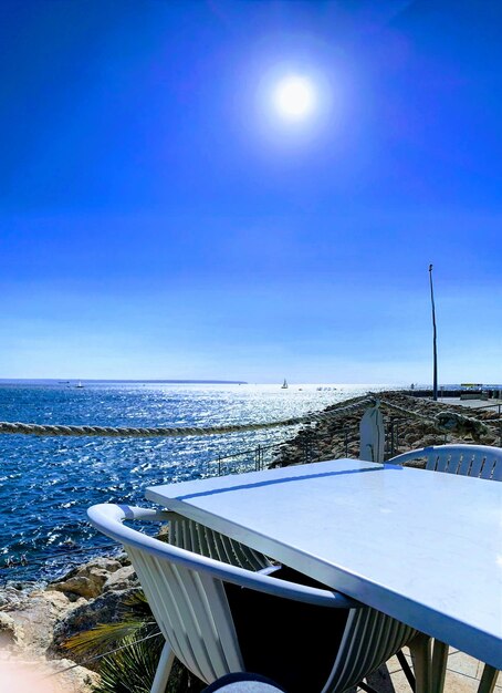 Swimming pool by sea against clear blue sky